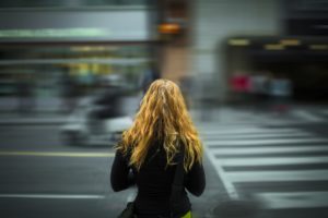 Woman facing road with traffic